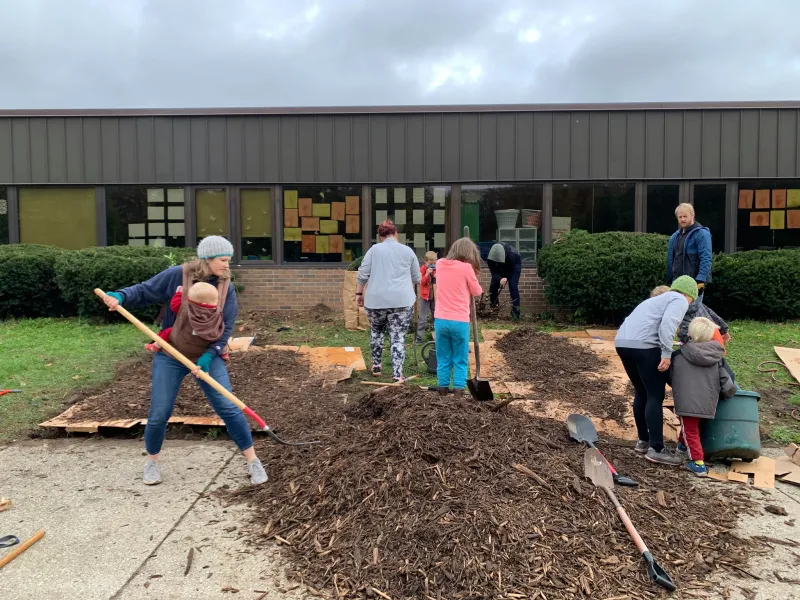 Teachers, parents, and students working on a native plant garden.