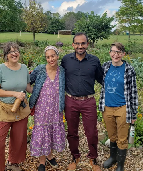 Four farmers of mixed age, gender, and skin color looking at the camera.